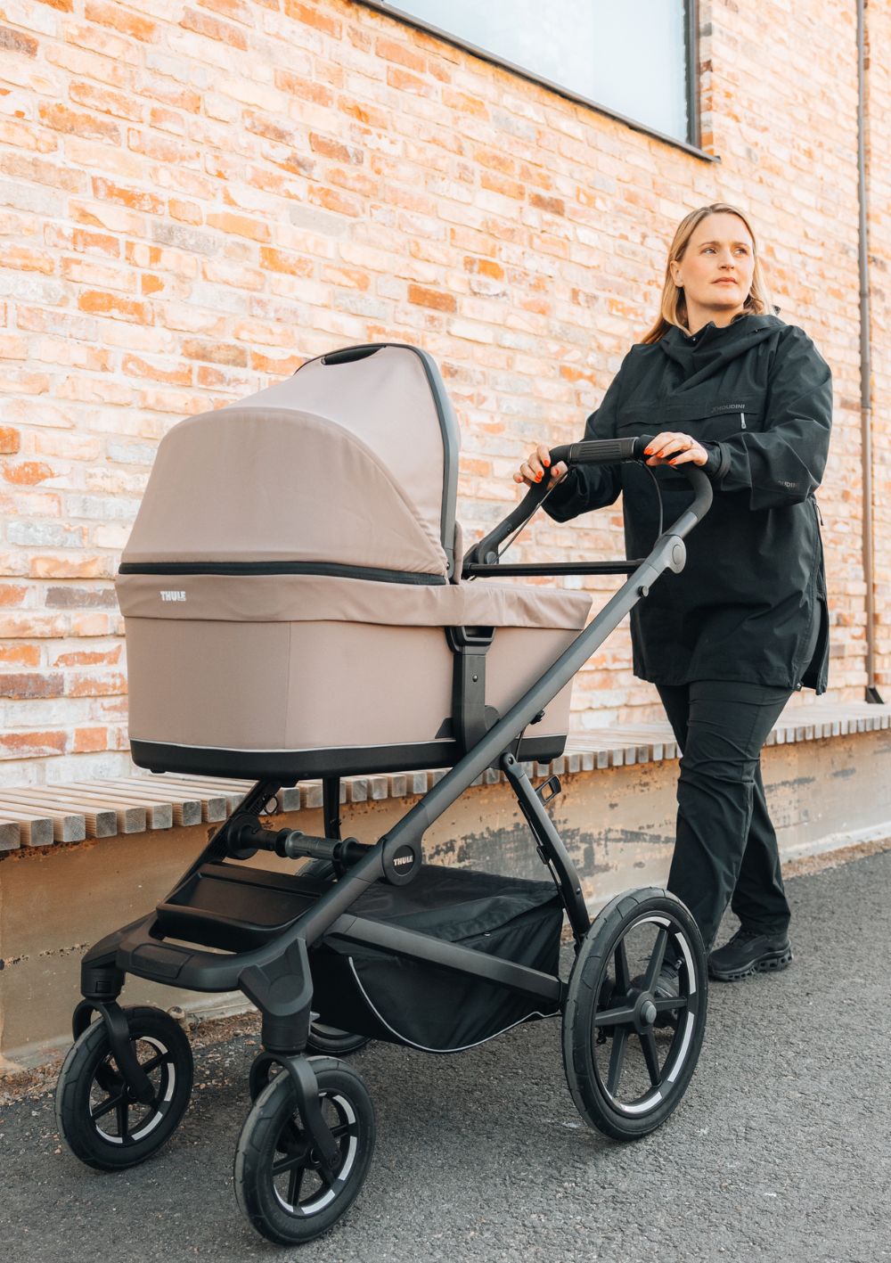 Frau schiebt Thule Kinderwagen Urban Glide 4-wheel mit Babywanne 'Urban Glide' Tinted Taupe