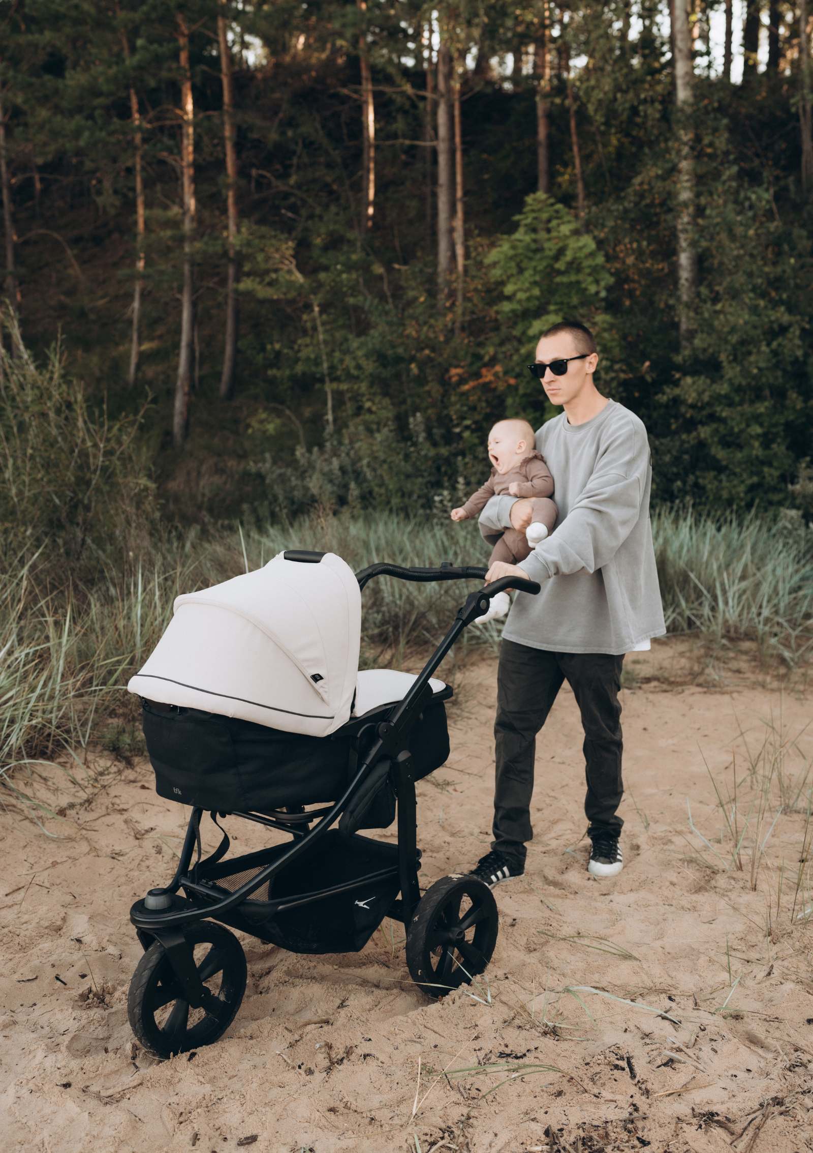 Mann und Baby mit TFK Kombi-Kinderwagen 'Mono 3' Sand am Strand