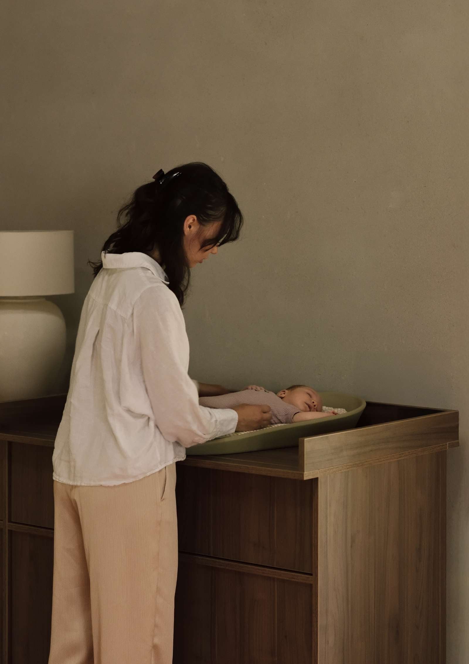 Frau wickelt Baby auf Quax (Wickel-)Kommode 'Kyo' Walnut