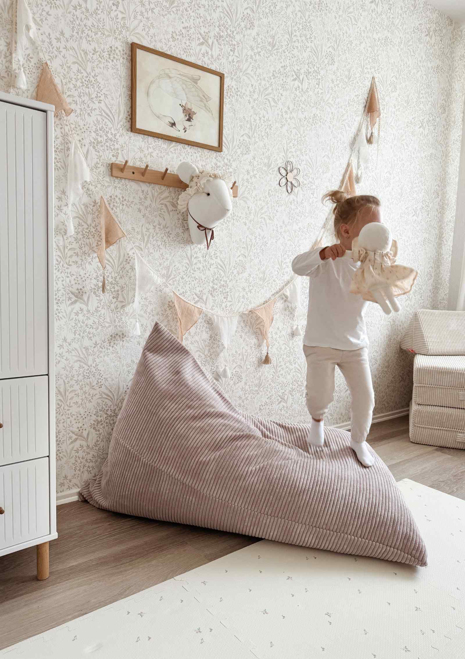 Mädchen springt vom Funzy Lounger Sitzsack Cord Kirschblüte Rosa