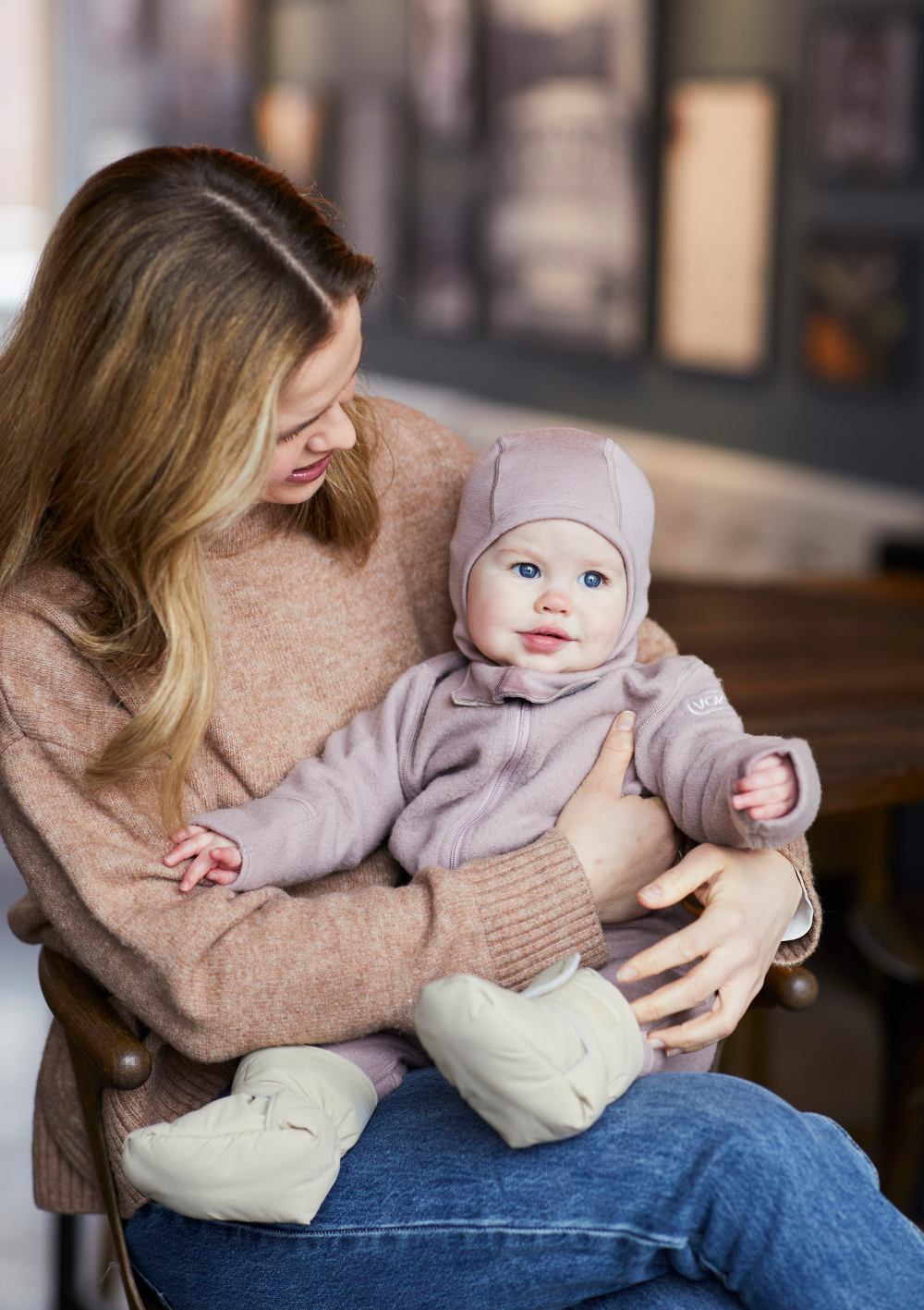 Frau mit Baby, das Voksi Baby Booties Seashell Sand trägt