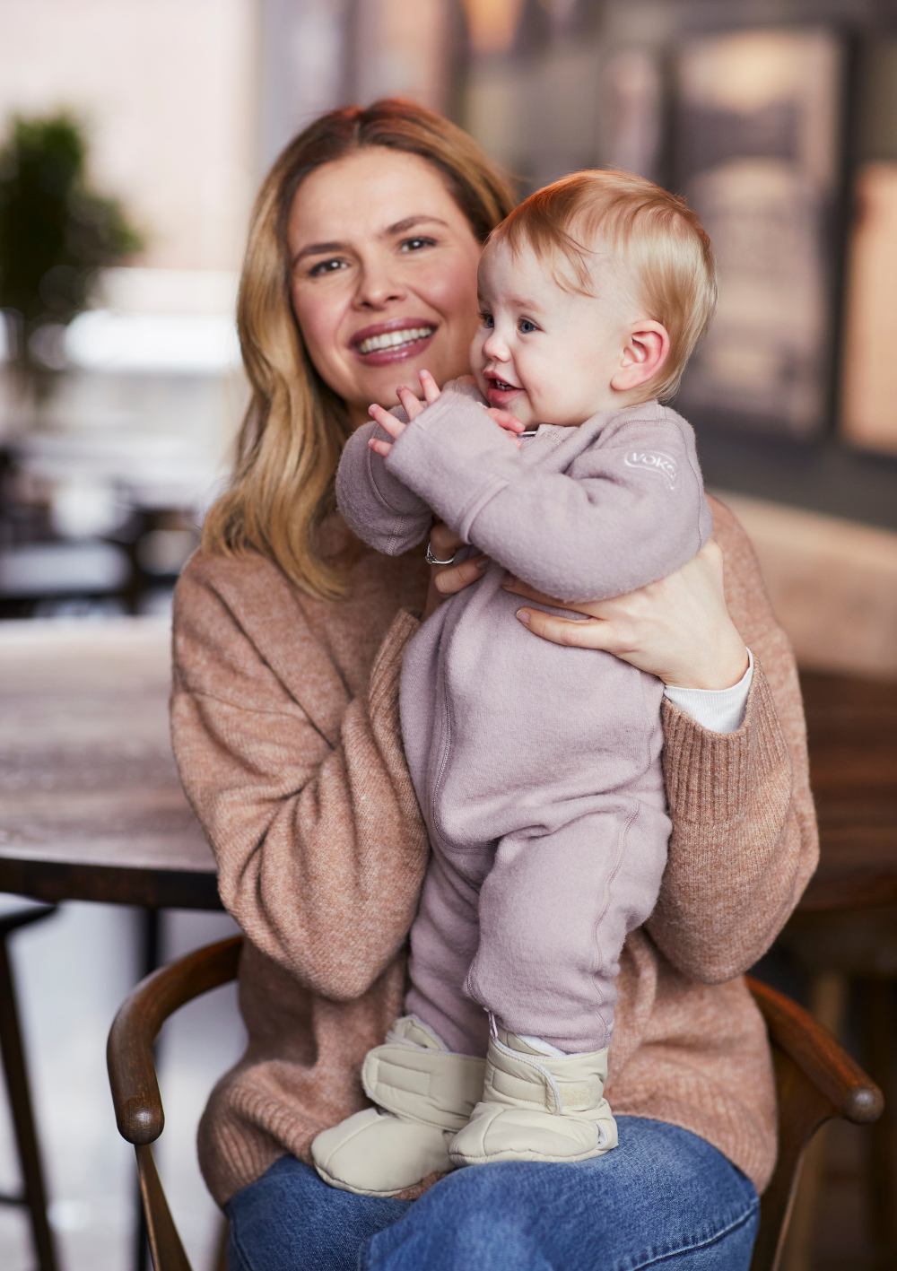 Frau mit Baby, das Voksi Baby Booties Seashell Sand trägt