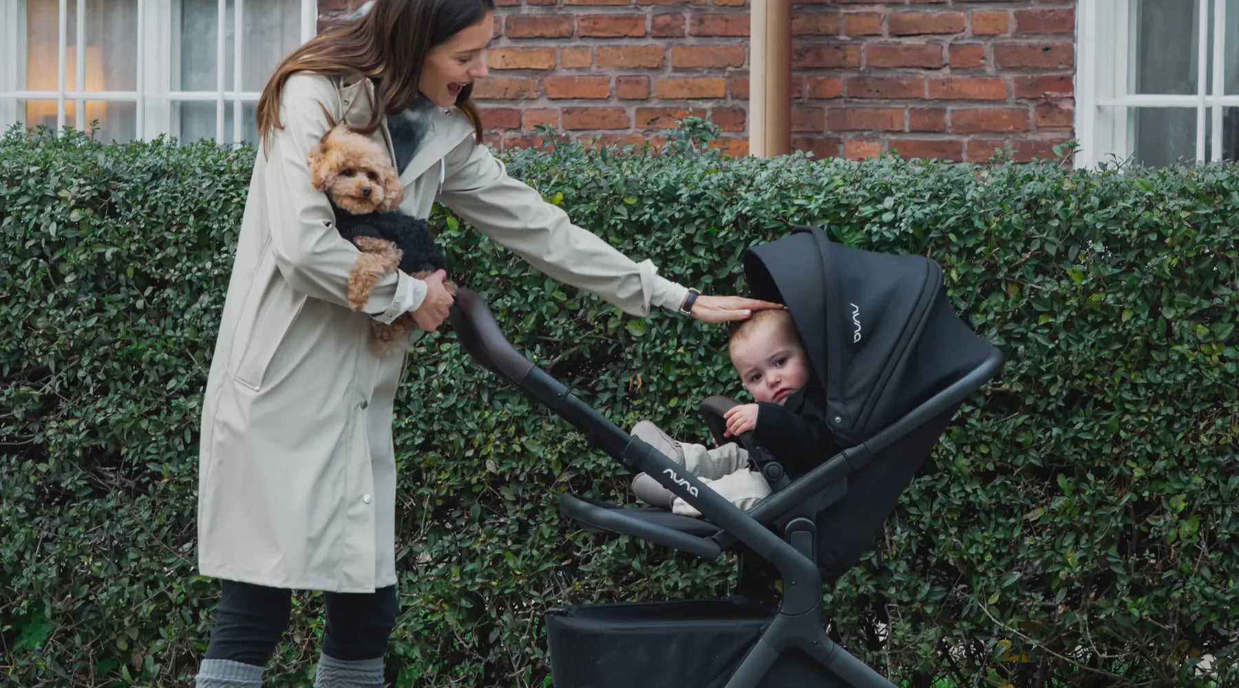 Nuna DEMI icon – im Bild: Frau mit Hund auf dem Arm schiebt Sportwagen Nuna DEMI icon 