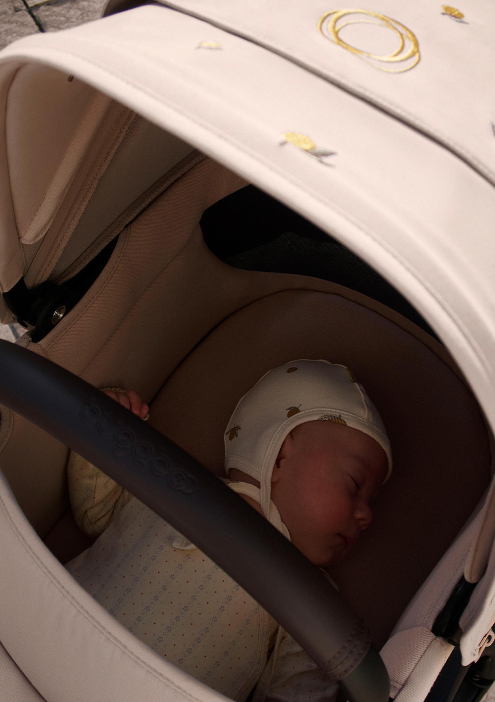 Bugaboo Kinderwagen-Set 'Fox 5 Renew x Konges Sløjd' Wüstentaupe Melange / Lemon - Baby liegt in Babywanne und schläft, mit passendem Lemon Baby-Mützchen von Konges Slojd