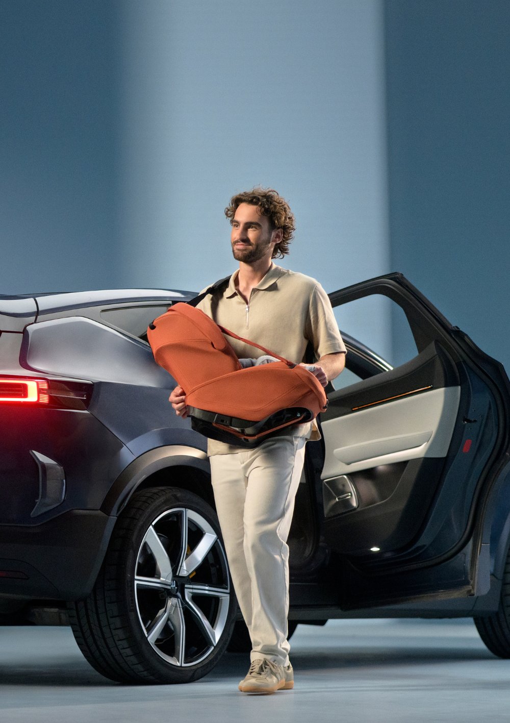 Mann trägt  Maxi-Cosi Babyschale 'Coral Slide Pro' Copper Terra mit Tragegurt