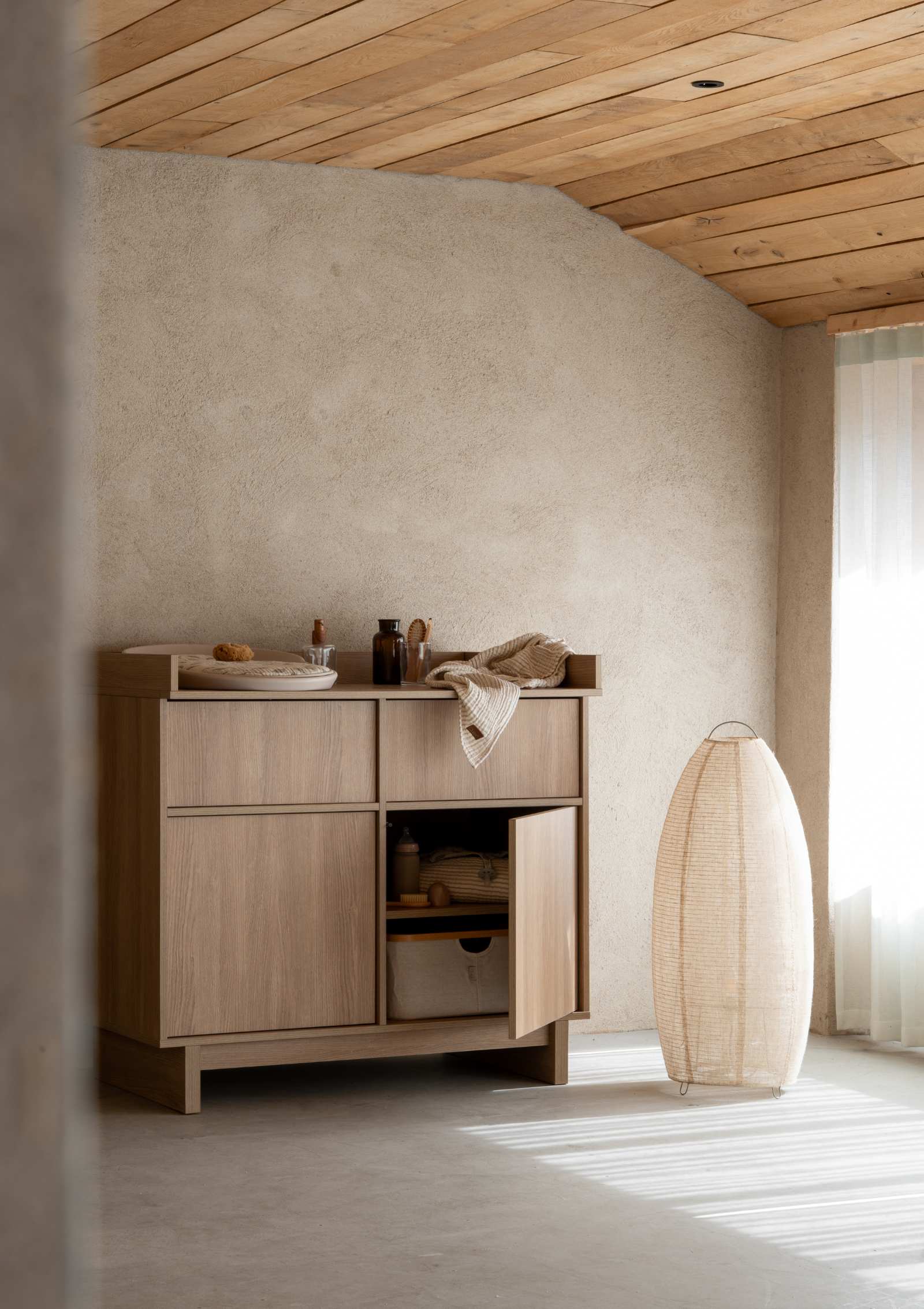 Quax (Wickel-)Kommode 'Kyo' Honey Ash mit Wickelkissen und Alltagsutensilien und Aufbewahrungskorb im Fach