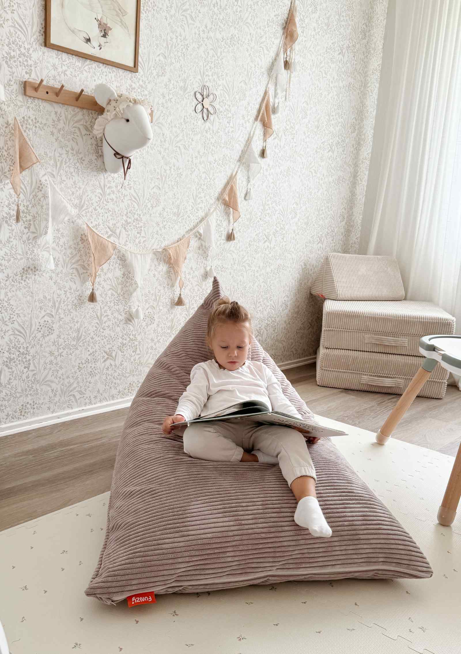 Mädchen liest Buch im Funzy Lounger Sitzsack Cord Kirschblüte Rosa