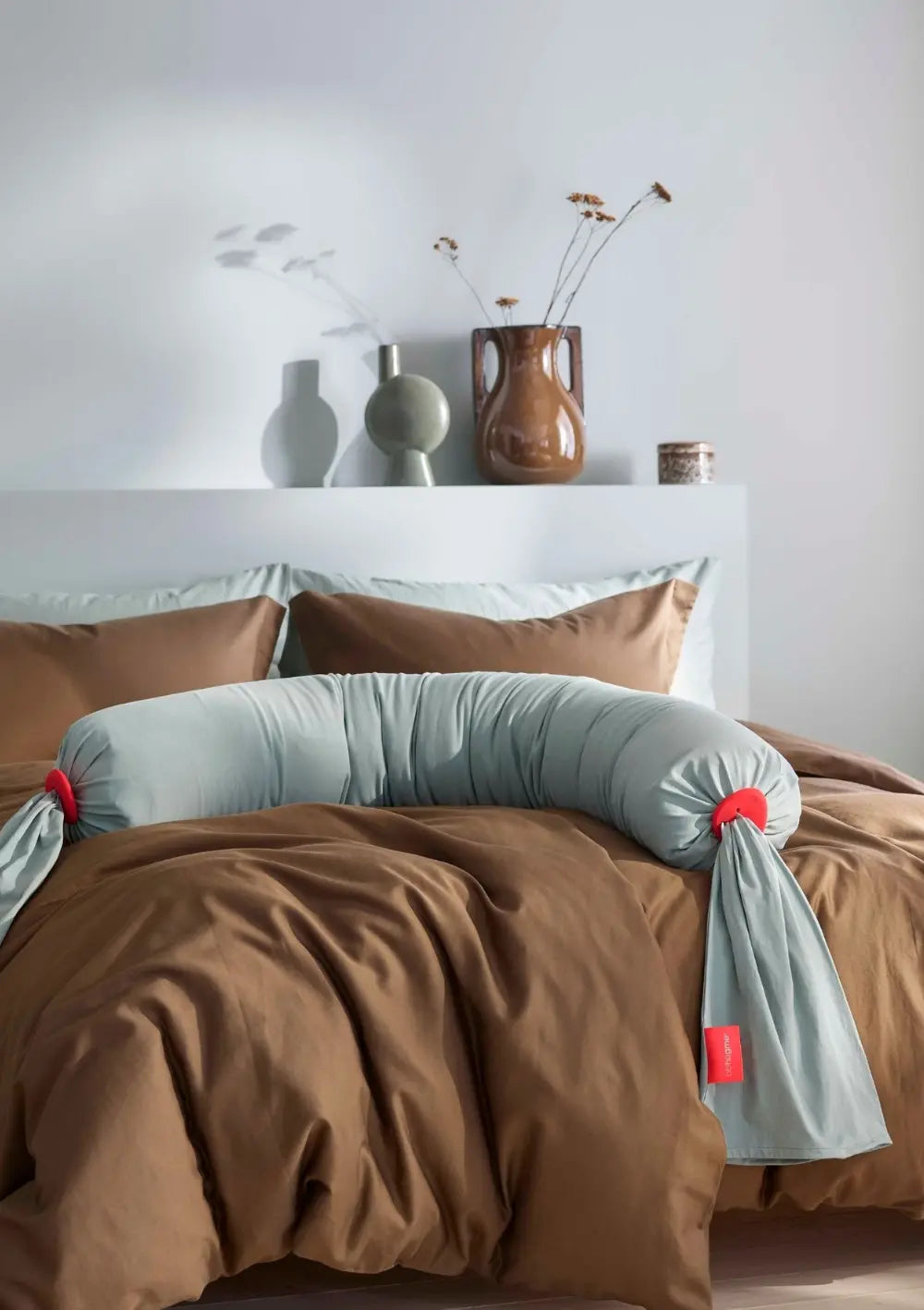 bbhugme Schwangerschaftskissen Eucalyptus liegt auf einem Doppelbett in einem modern eingerichtetem Schlafzimmer