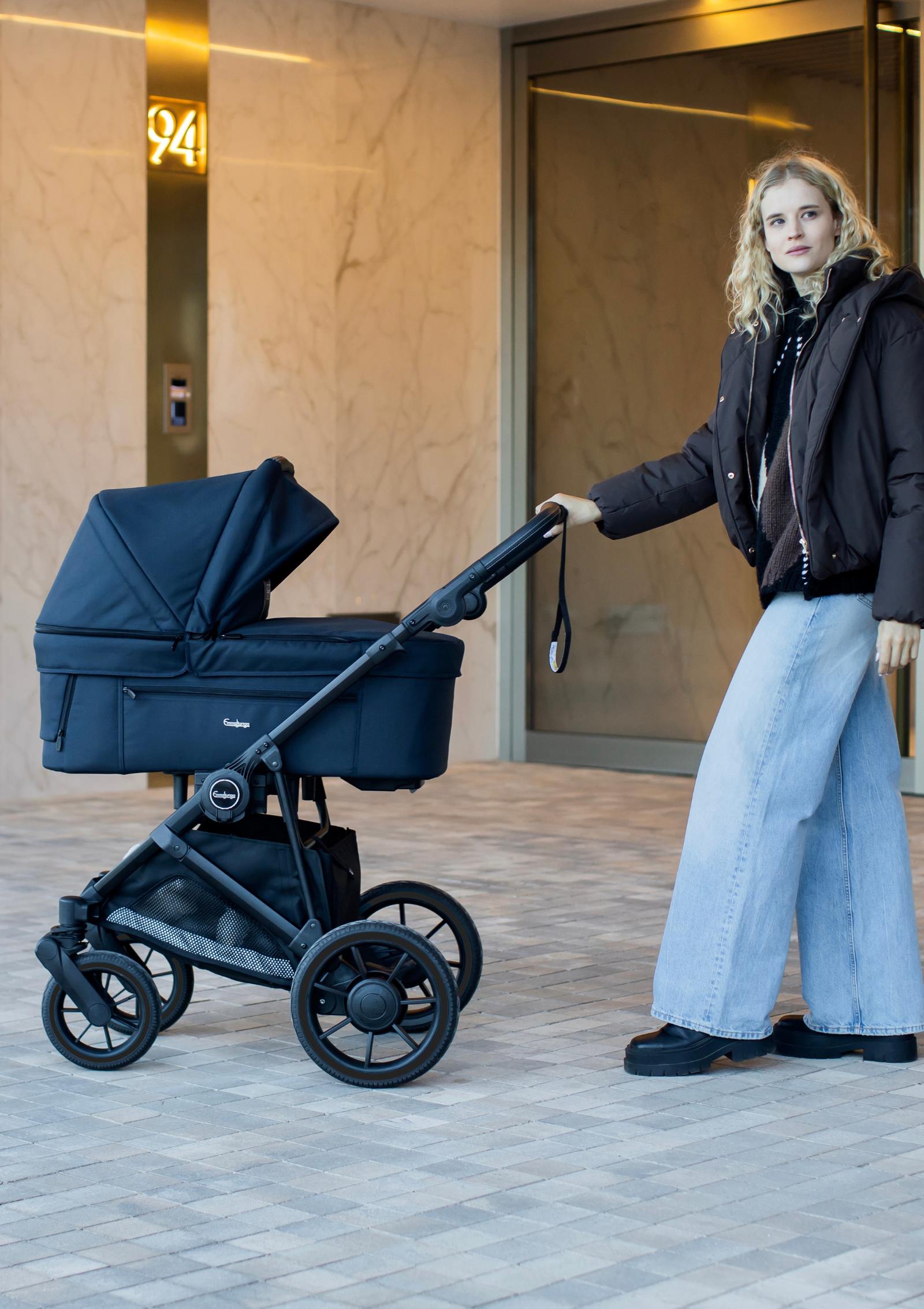 Frau schiebt Emmaljunga Kinderwagen 'SUPER SONIC' Urban Dark Navy