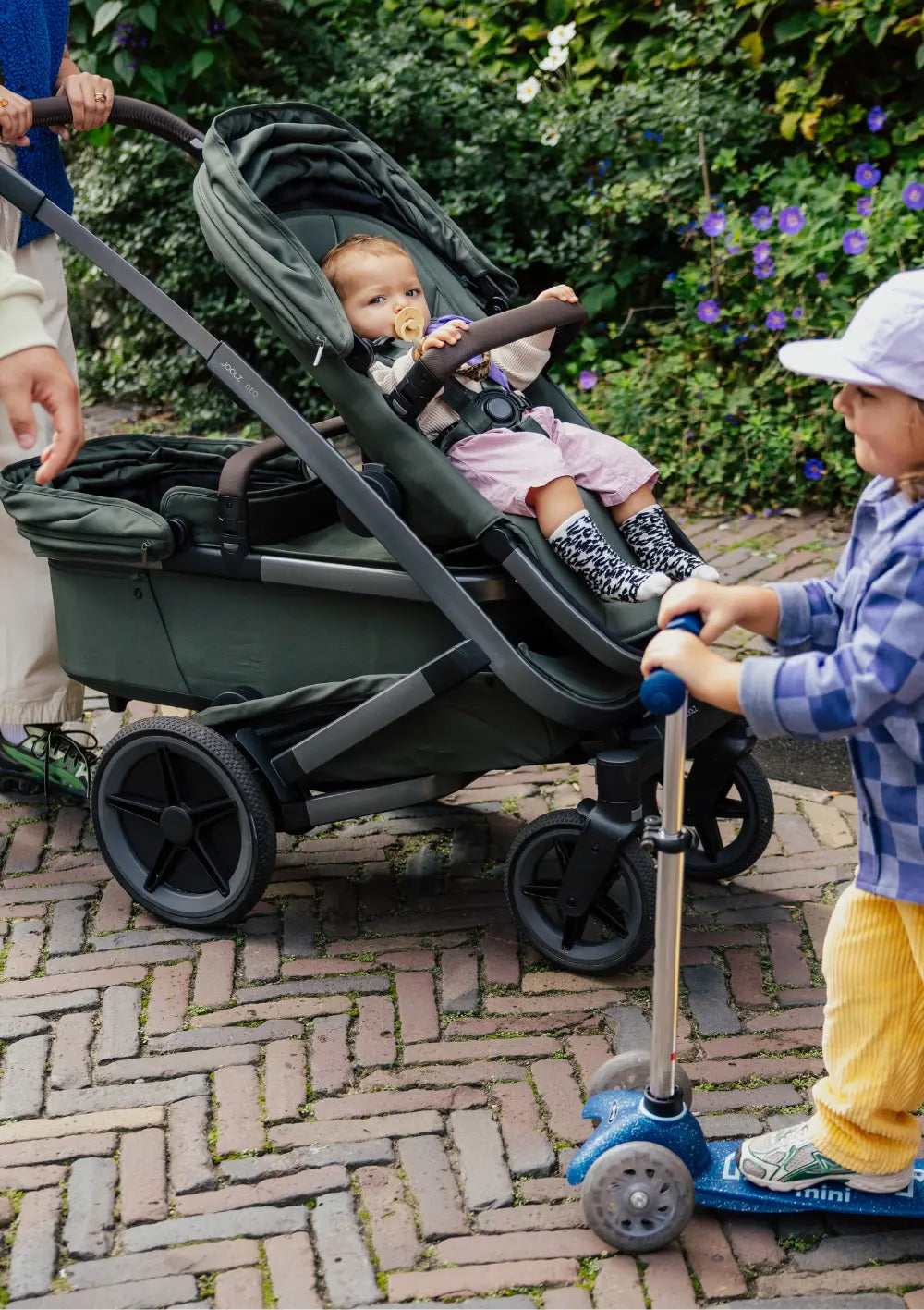 Kind sitzt in oberem Sportsitz im Joolz Geschwisterkinderwagen-Set 'Geo5 Double' Forest Green