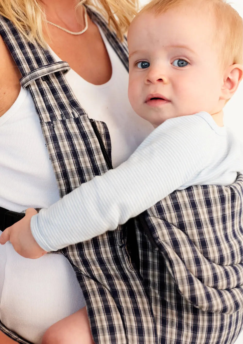 Nahaufnahme eines Babys in der Moova Babytrage 'Balance' Navy Check