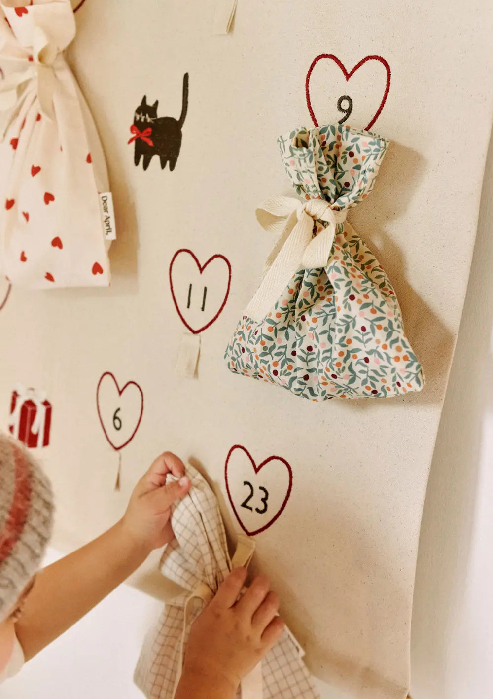 Detailaufnahme eines floral bedruckten Stoffbeutels aus dem Dear April 6er-Set Geschenkbeutel Hollis Mix, der an dem dazu passenden Halo Adventskalender hängt.