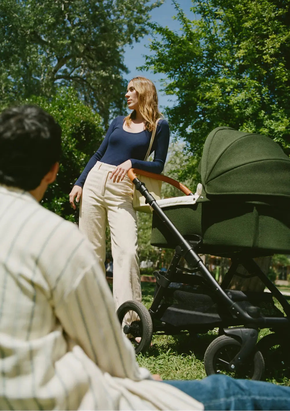 Frau im Park lehnt sich am Schiebegriff des Angelcab Kinderwagens 'U3-Series' Kentish an